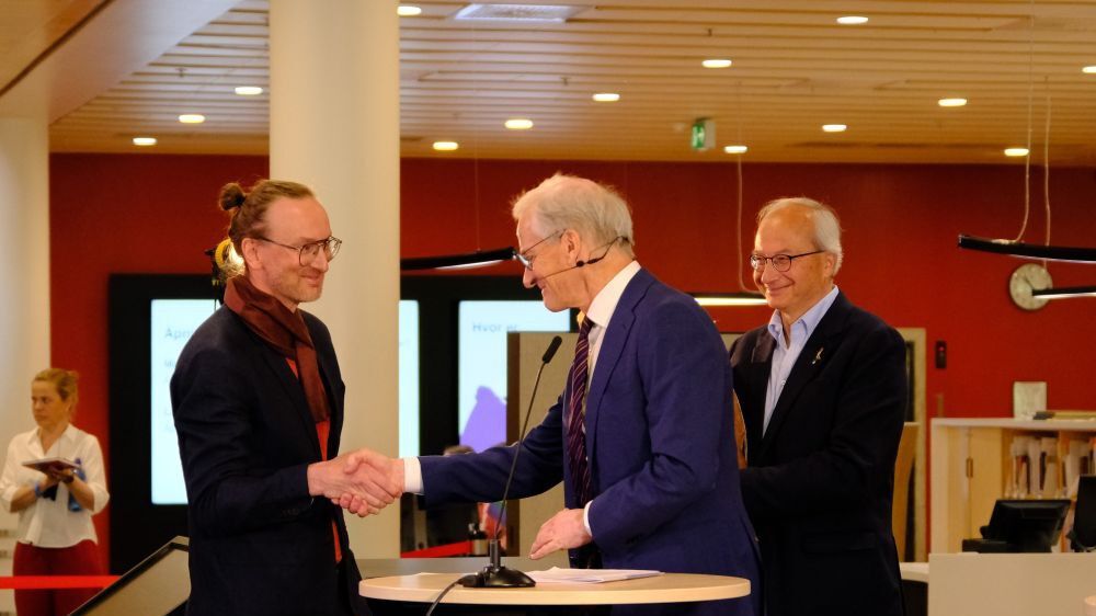 Alexander Refsum Jensenius shaking hands with Jonas Gahr Støre, with Arnoldo Frigessi beside them